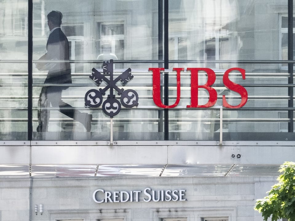 Ein UBS-Logo über einem Credit-Susisse-Logo.
