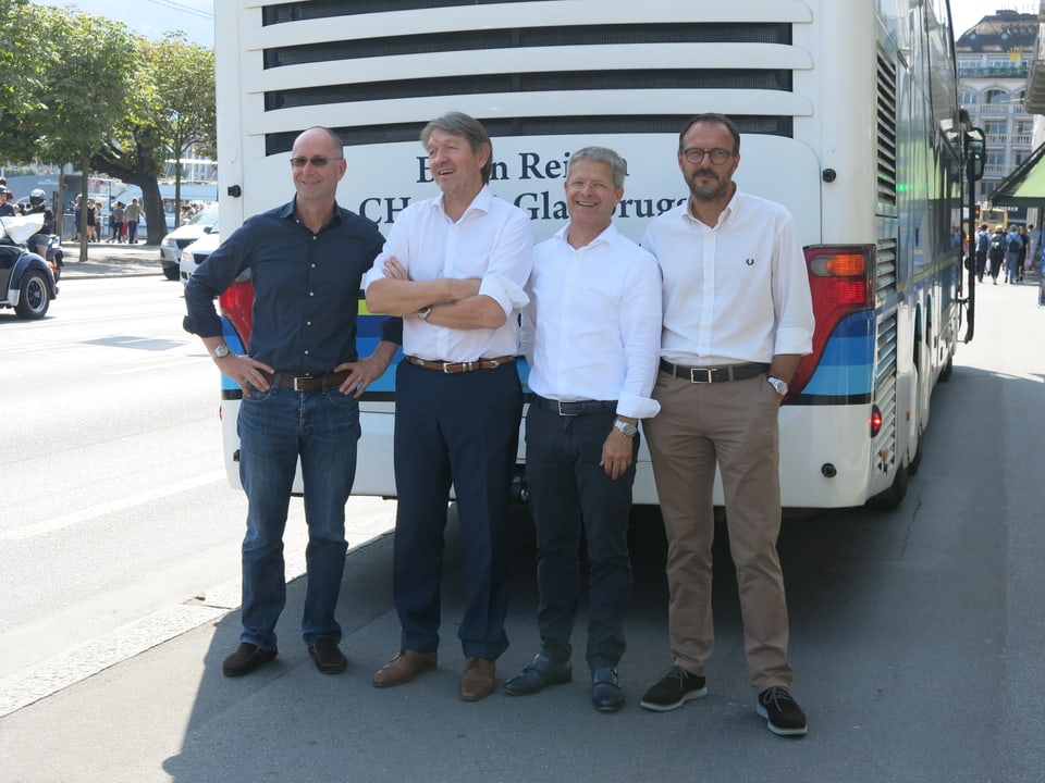 Vier Männer vor einem Reisecar