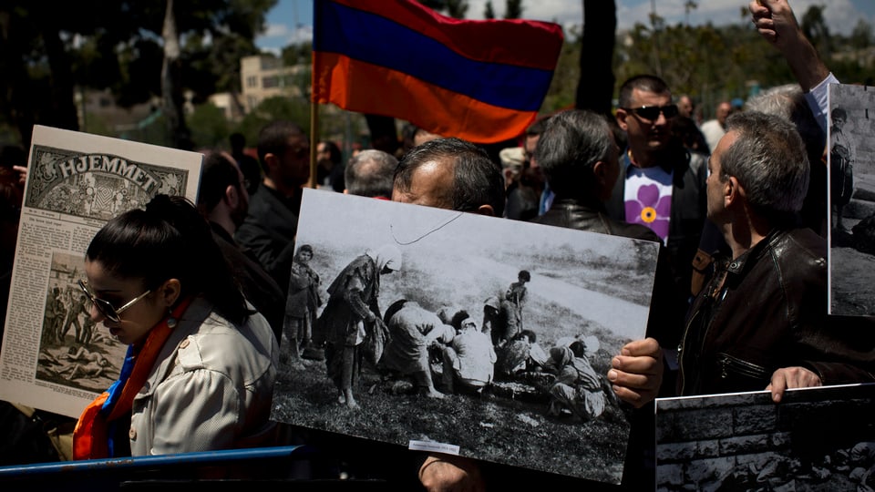 Ein armenischer Demonstrant hält ein Bild des Genozids an Armenier durch die Türken.