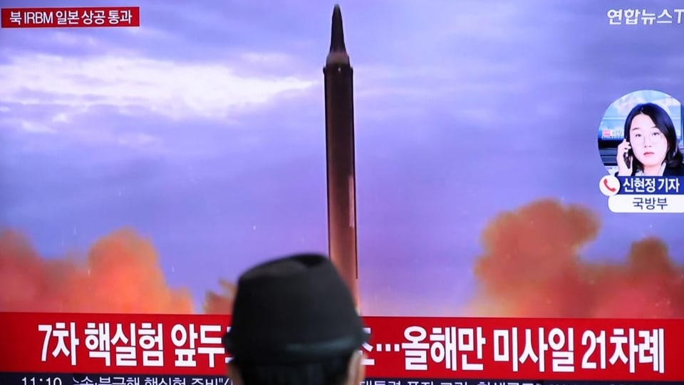 Ein Nordkoreaner schaut den Abschuss der Rakete im Staatsfernsehen. Perspektive: Von hinten.