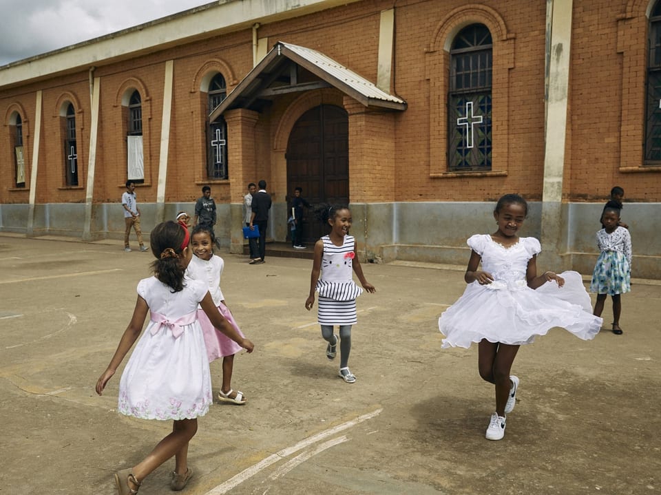 Kinder spielen vor einer Kirche