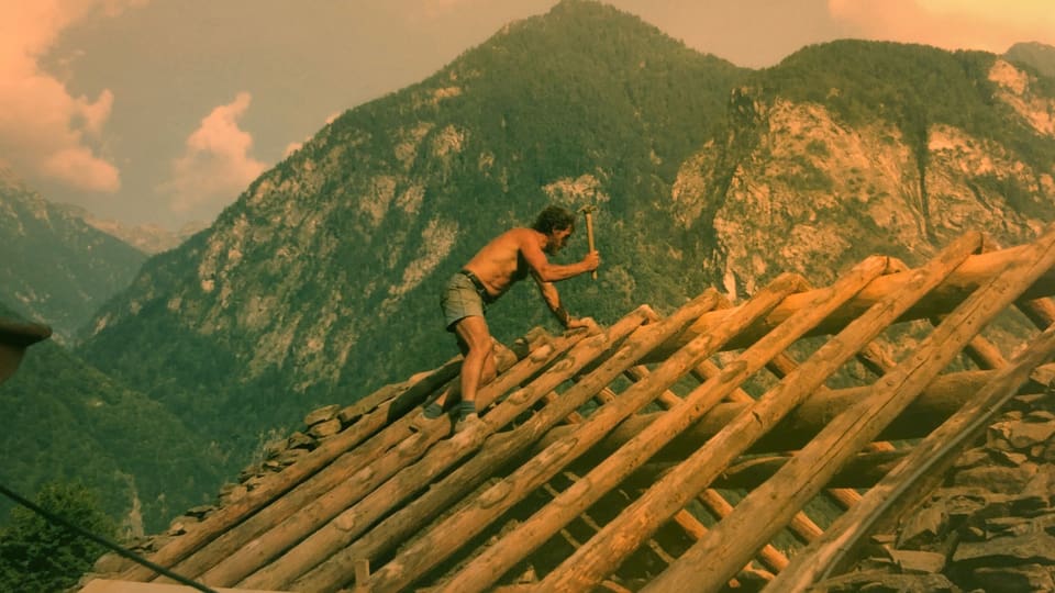 Ein Zimmermann arbeitet an einem Holzdach.
