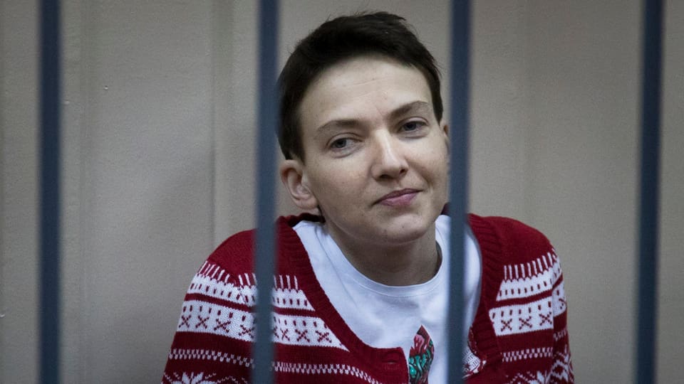 Nadja Sawtschenko sitzt lächelnd hinter Gittern