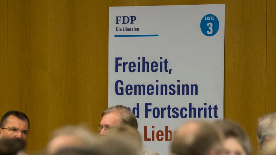 An einer Wand hängt ein Wahlplakat der FDP