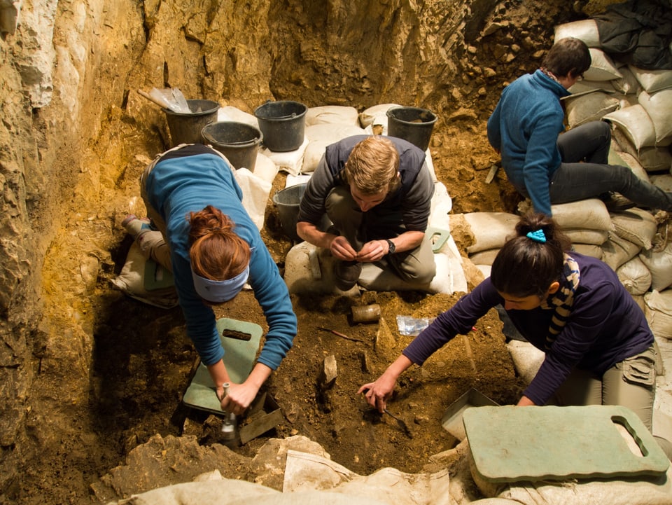 Archäologiestudierende tragen unter Anleitung einer Grabungstechnikerin der Universität Tübingen die Erdschichten millimeterweise ab.