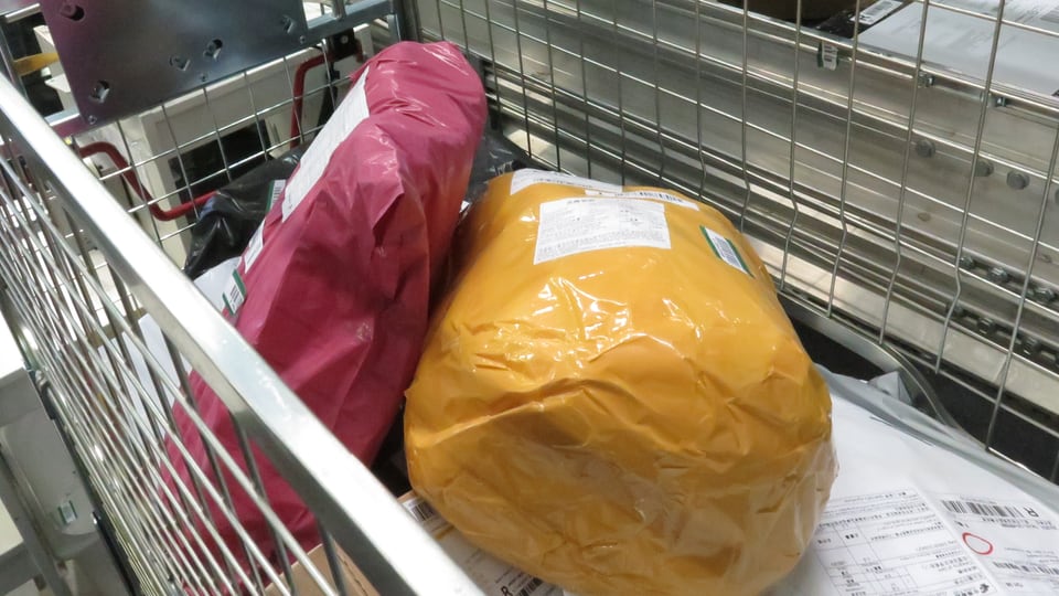 Zwei in farbigem Plastik eingehüllte Postsendungen