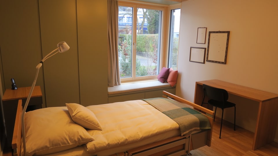 Ein Bett in einem farbig eingerichteten Zimmer.