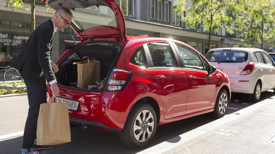 Ein Mann steht vor einem Mobility-Auto