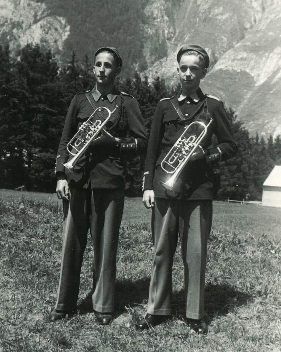Zwei Trompeter in Kadetten-Uniform auf einer Wiese.