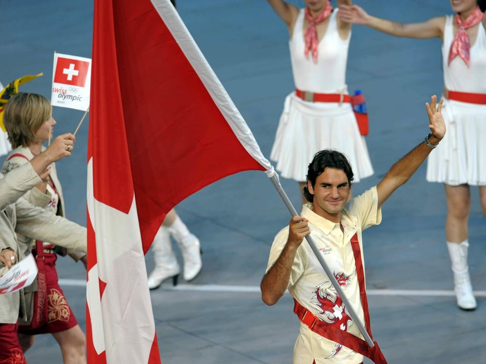 Roger Federer hält 2008 die Fahne und winkt ins Publikum.