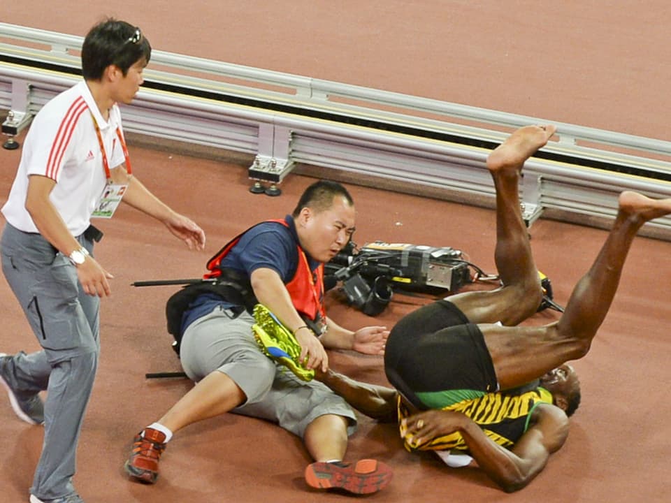 Usain Bolt macht einen Überschlag auf dem Boden. 