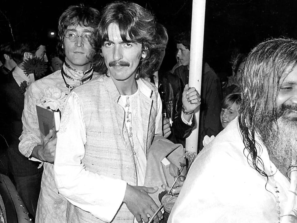 Schwarzweissfoto: Zwei Männer im Stil der Siebzigerjahre, im Vordergrund ein Mann mit langem Bart und Haar