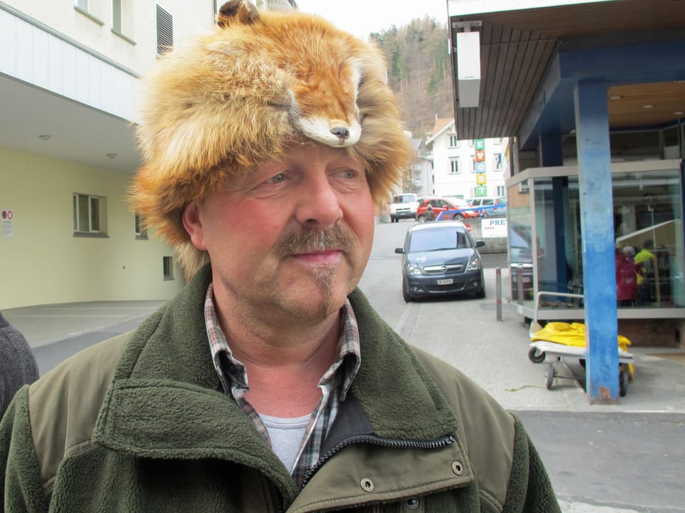 Mann trägt ein Fuchsfell in Hutform auf dem Kopf