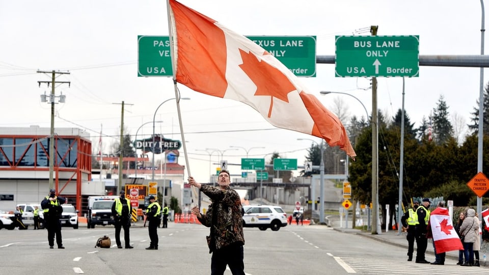 Ein Demonstrant schwenkt die kanadische Flagge.