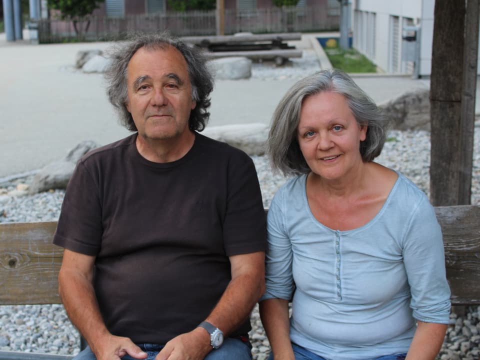 Ein älteres Paar sitzt auf einer Bank.