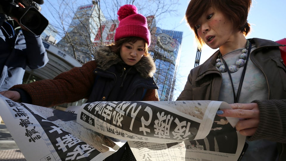 Japanerinnen mit Zeitung.