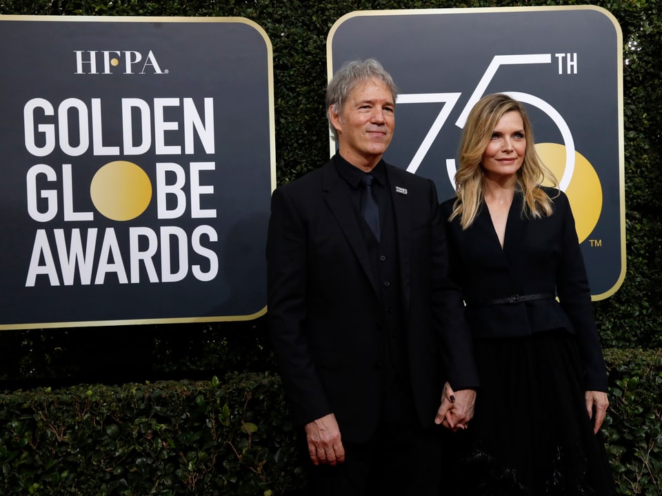 Ein Mann und eine Frau, beide in schwarz, vor einem Schild mit der Aufschrift «Golden Globe Awards».