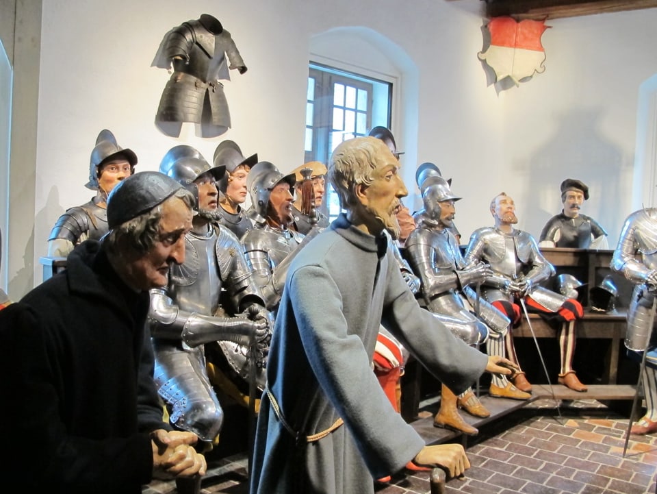 Puppen in historischen Rüstungen und Kleidern.