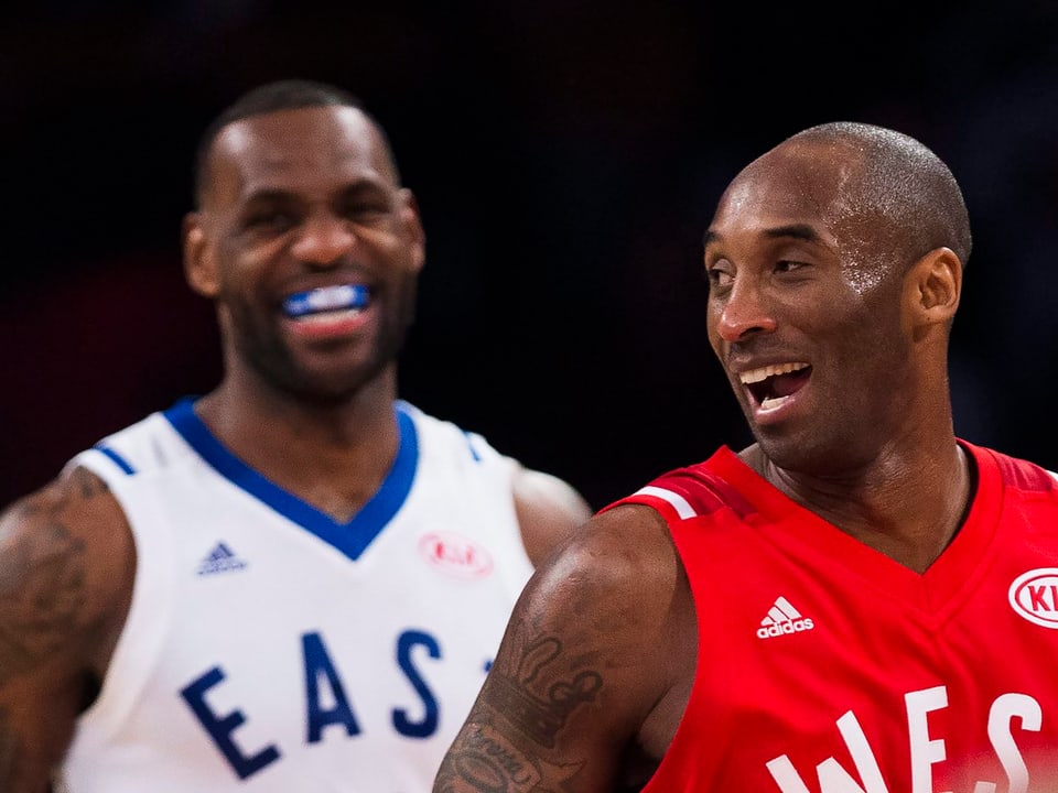 Kobe Bryant und LeBron James lachen auf dem Spielfeld.