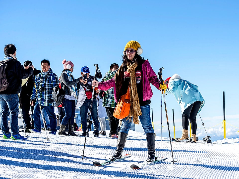 Eine chinesische Touristin versucht sich beim Skifahren