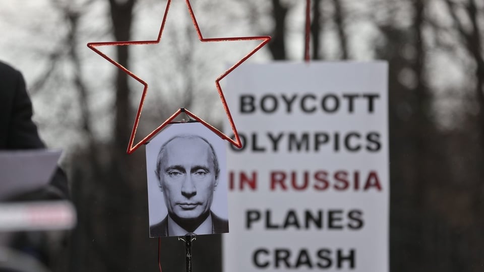 Schild mit Gesicht von Wladimir Putin, einem roten Stern und dem Schriftzug «Boycott Olympics in Russia Planes Crash»