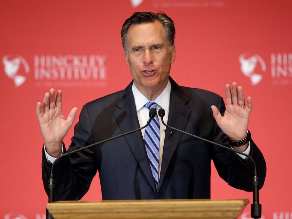 Mitt Romney spricht an Tagung ins Mikrofon. 