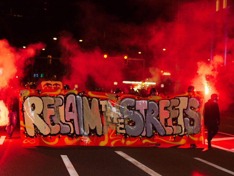 Vermummte Demonstranten der «Reclaim-the-Streets»-Bewegung sind in der Innenstadt von Zürich mit Spruchbändern und Leuchtfackeln unterwegs. (keystone)