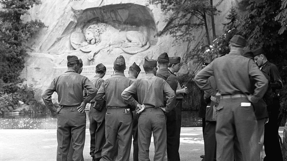 Schwarz-Weiss-Aufnahme von amerkanischen Soldaten vor dem Löwendenkmal