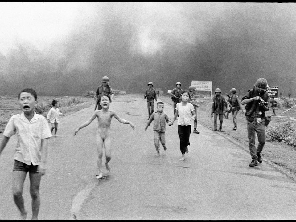Ein nacktes Mädchen mit furchterfülltem Gesicht flieht vor einem Napalm-Bombenangriff in Vietnam. 