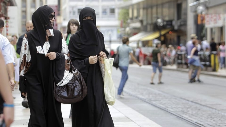 Zwei Frauen verhüllt auf der Strasse. 