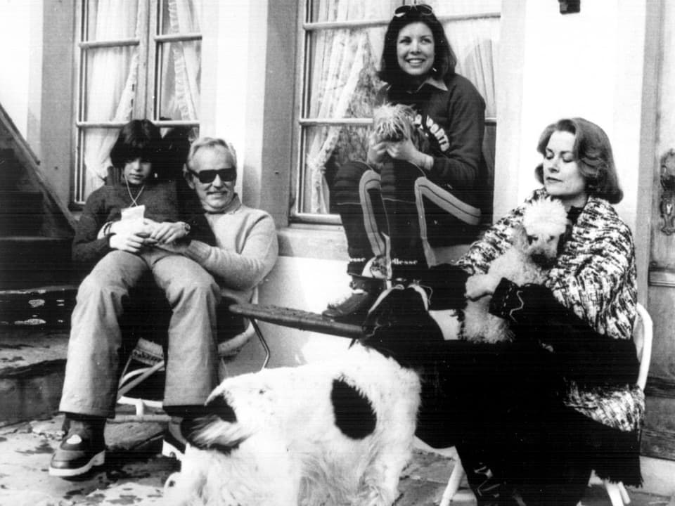 Die Fürstenfamilie vor ihrem Chalet in Schönried. Grace Kelly und Caroline haben einen Hund auf dem Schoss. 