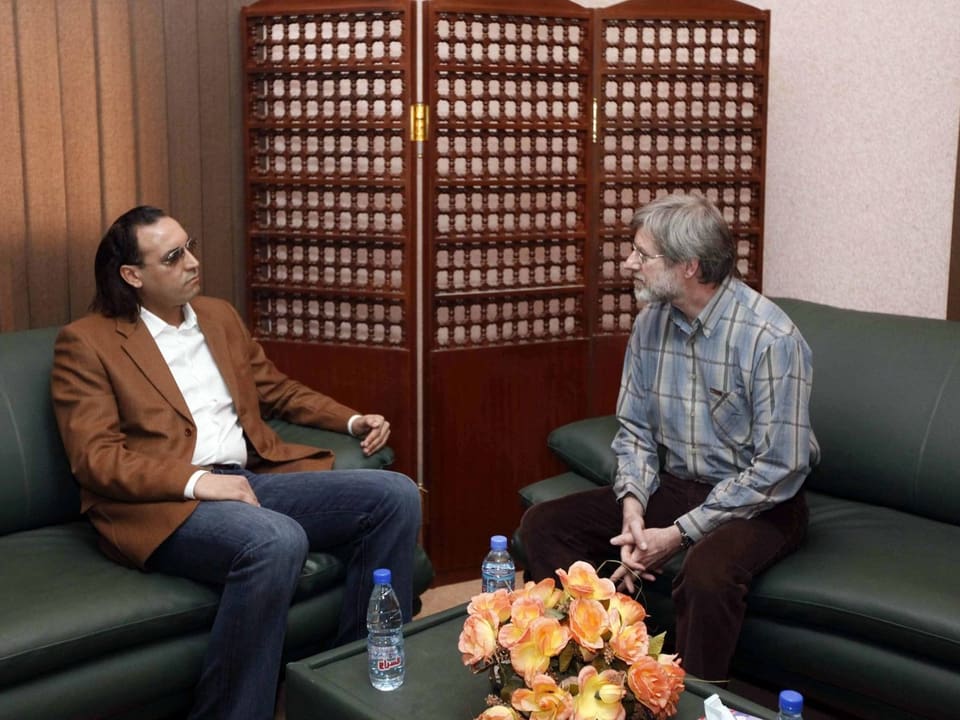 Hannibal Gaddafi (links, sitzend) mit Max Göldi (rechts, sitzend) im Gespräch.