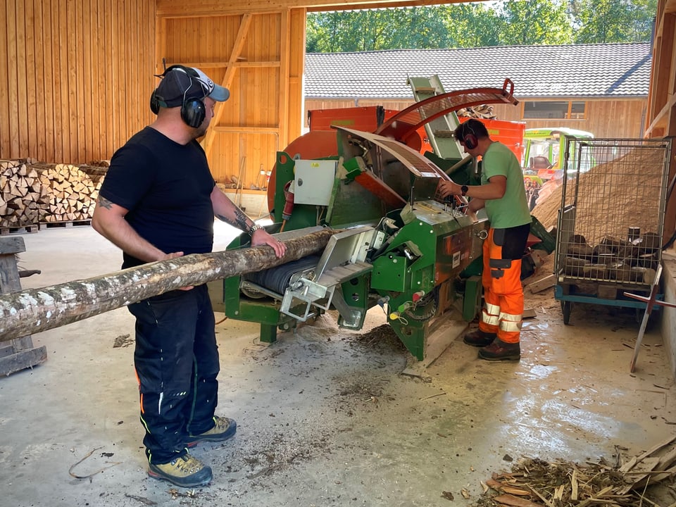 Beide Mitarbeiter arbeiten an der Maschine.