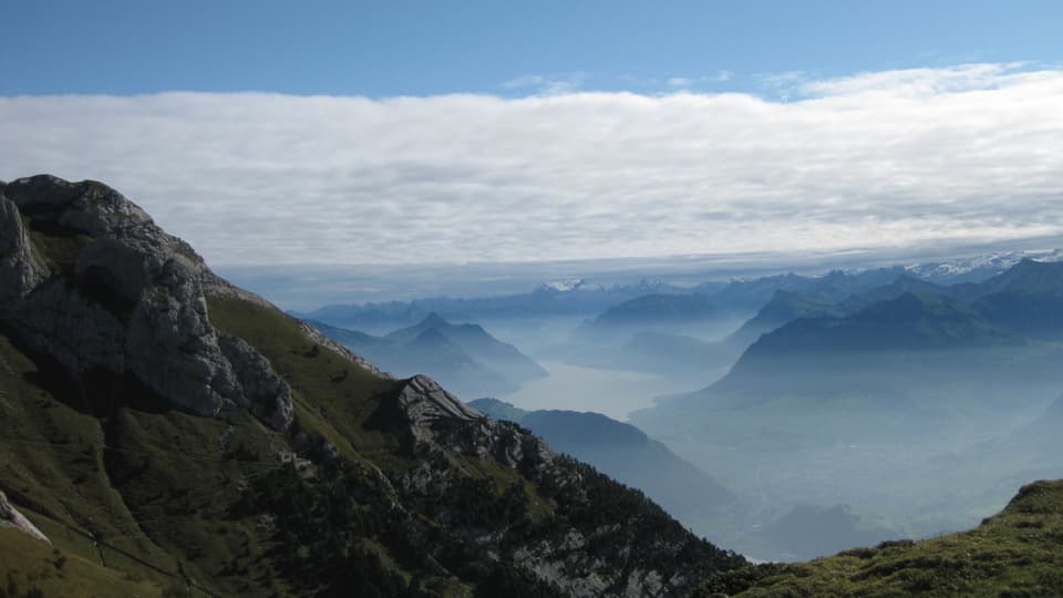 Blick vom Pilatus nach Osten. Im Vordergrund ist der Himmel wolkenlos. Richtung Ostschweiz sind dichte Wolkenfelder eines Kaltlufttroges zu erkennen.