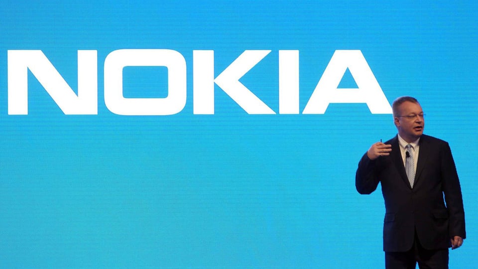 Elop vor einem grossen blau-weissem Nokia-Schriftzug.