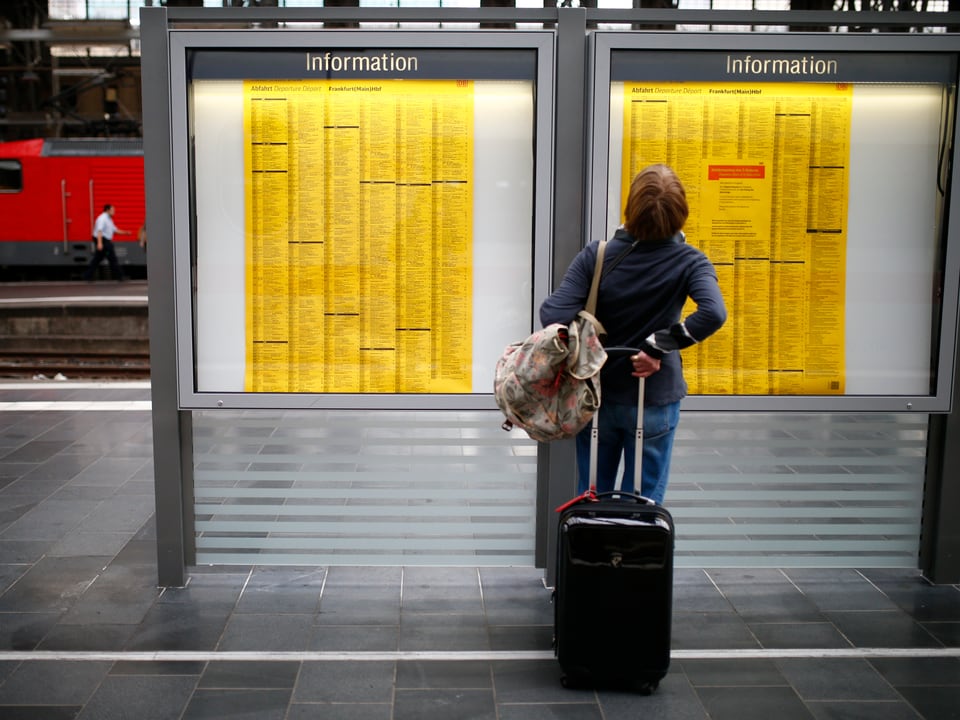 Ein Passagier prüft den Fahrplan auf einem Bahnperron in Frankfurt