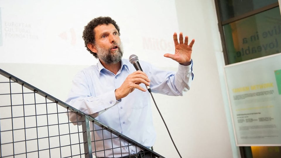 Osman Kavala spricht in ein Mikrofon.