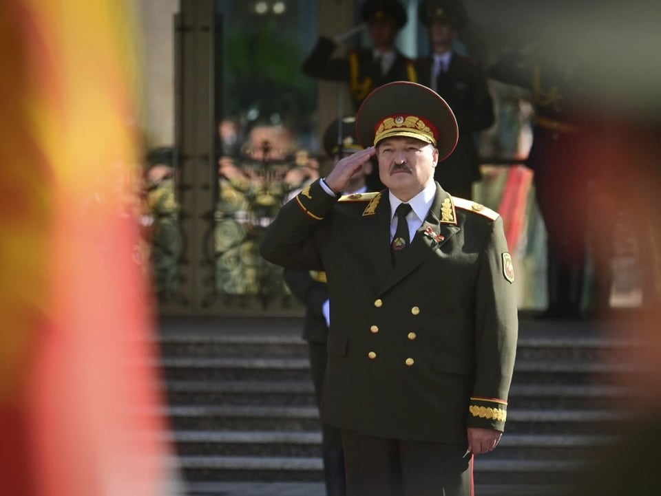 Lukaschenko salutiert in Uniform.