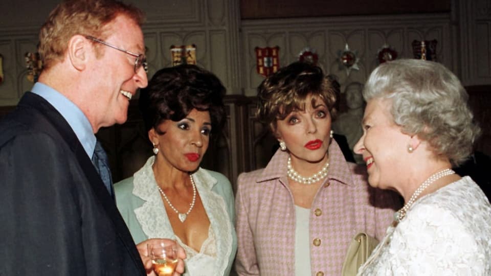 Mann im Gespräch mit zwei Frauen und Königin Elizabeth II.