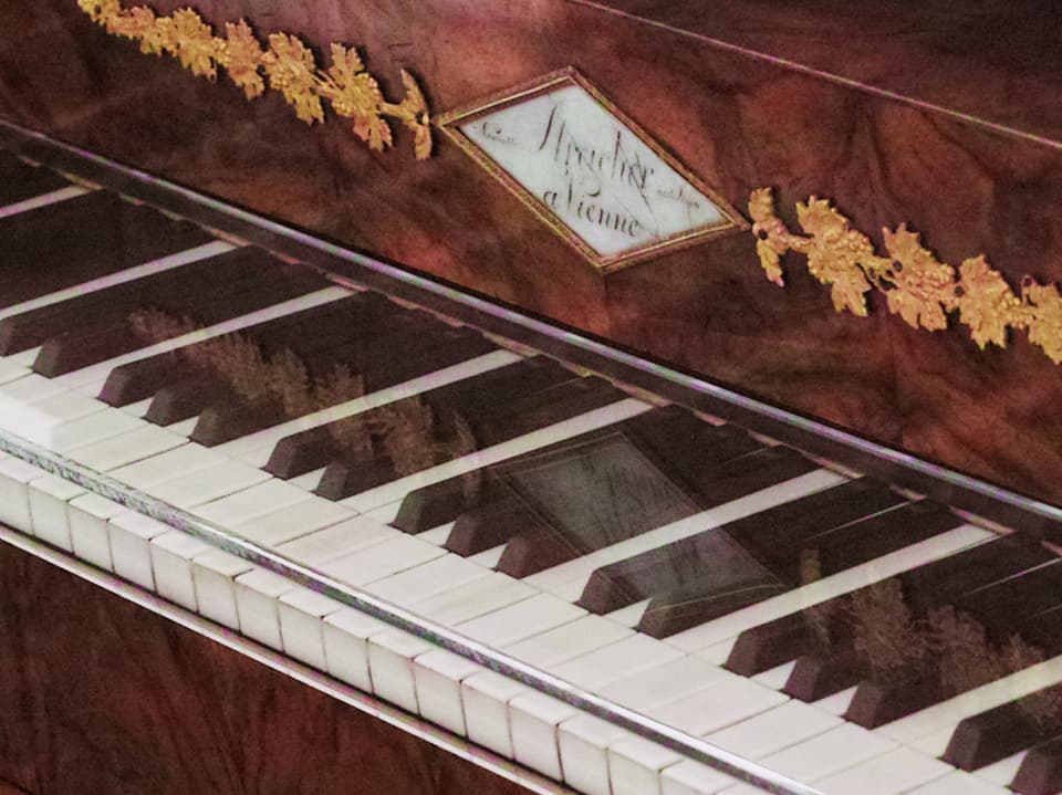 Die Tastatur eines alten Pianos mit der Aufschrift "Schtreicher"