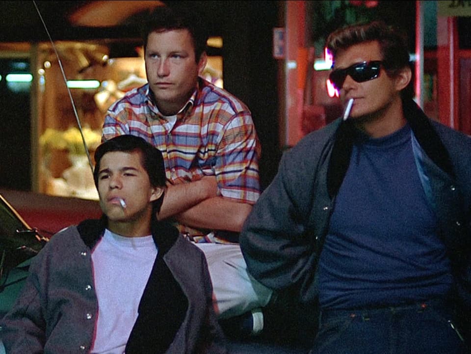 Drei Jugendliche, zwei mit Zigaretten, einer mit Sonnenbrille.