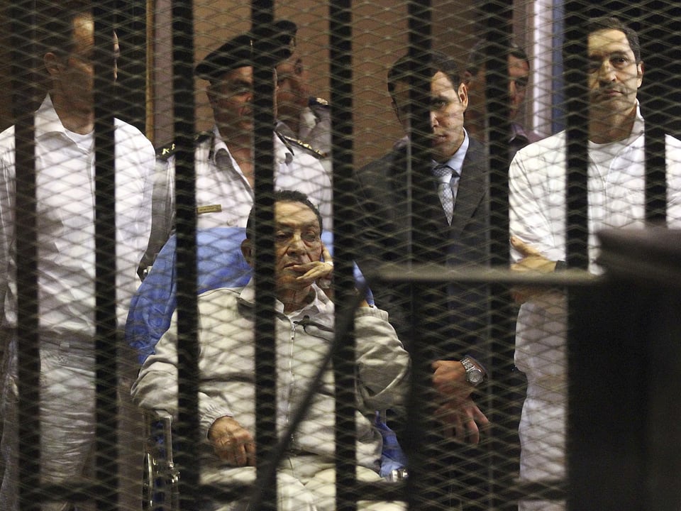 Mubarak verfolgt hinter Gittern auf einem Krankenstuhl sitzend den Prozess gegen ihn.