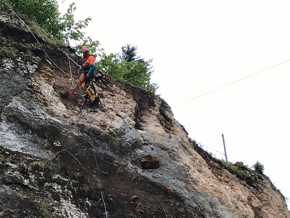 Kletterer an Seil in Felswand.