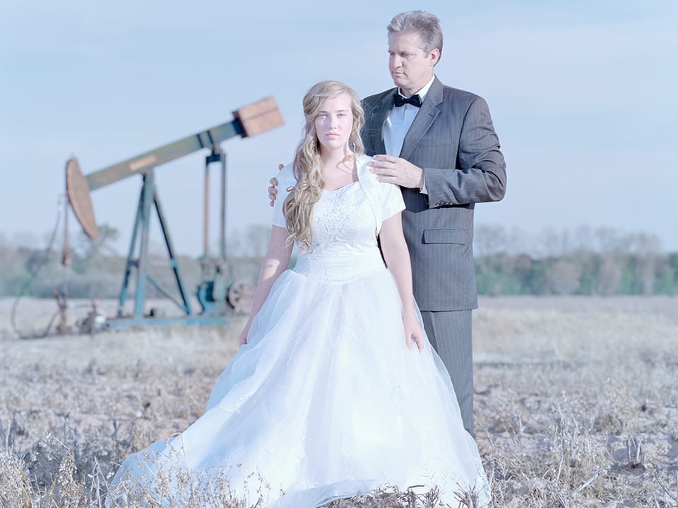 Vater mit Tochter im Brautkleid auf einem Feld