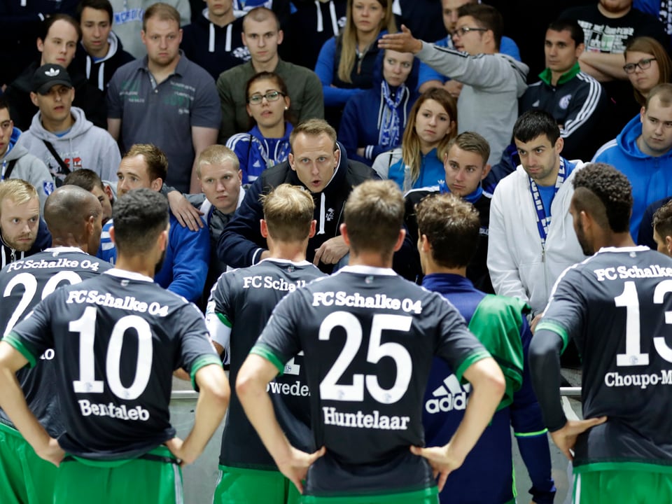 Spieler von Schalke 04 stehen nach dem 0:2 in Berlin mit hängenden Köpfen vor der Gäste-Fankurve und sprechen mit den Fans.