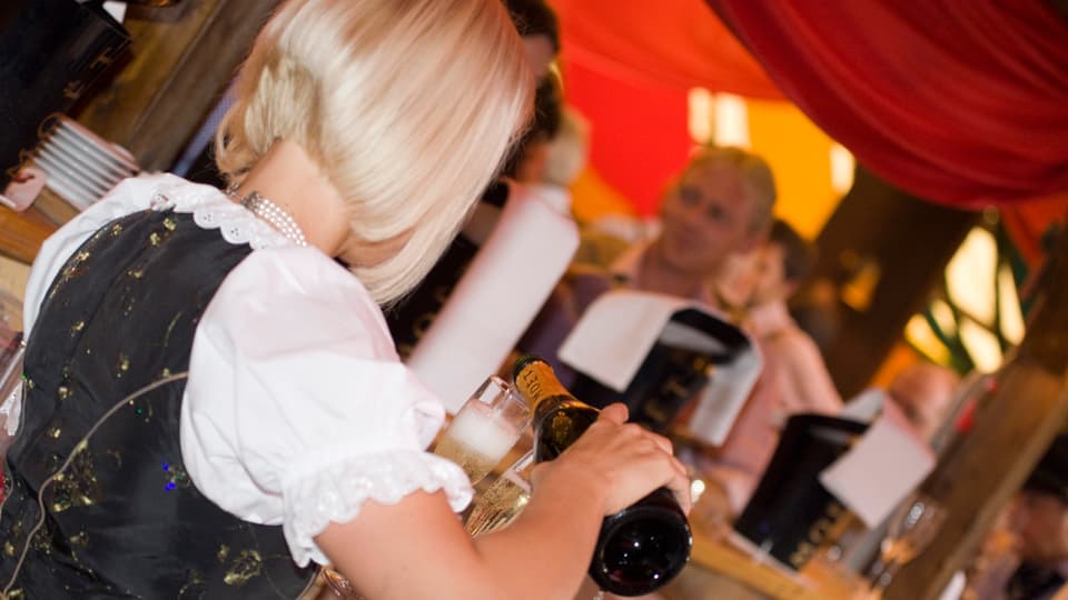 Eine Kellnerin schenkt Champagner ein.