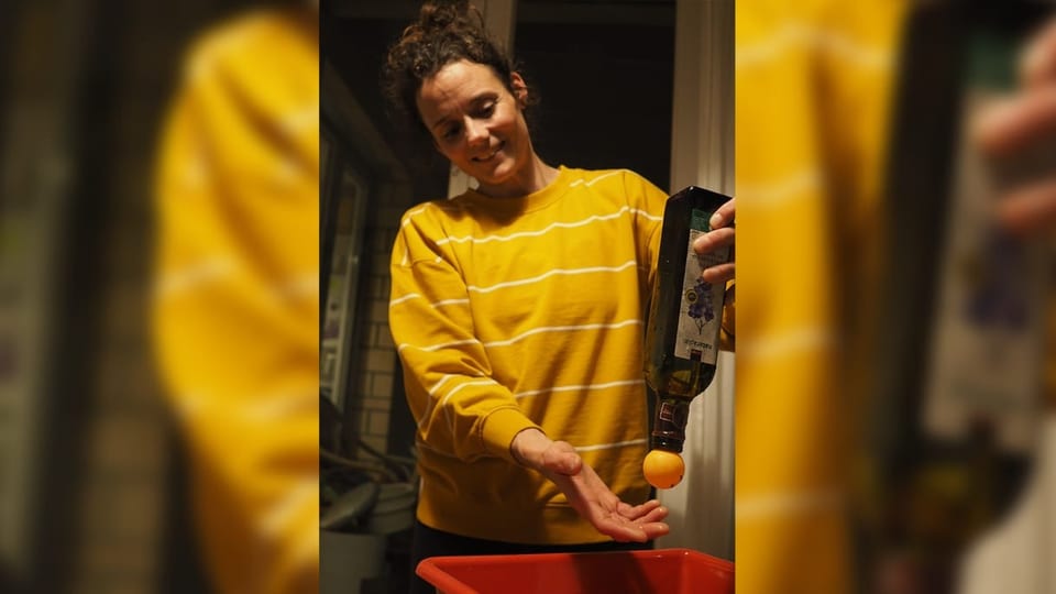 Cathrin Caprez mit einer gedrehten Flasche in der Hand. Ein Pingpong-Ball hält das Wasser in der Flasche.
