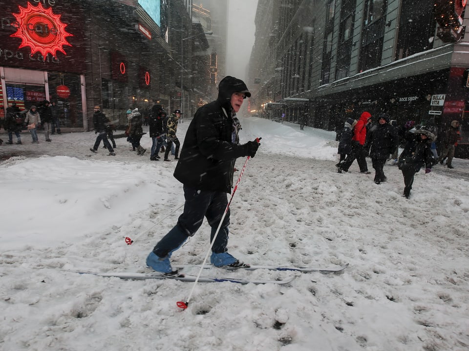 Ein Mann läuft auf Skiern durch New York.