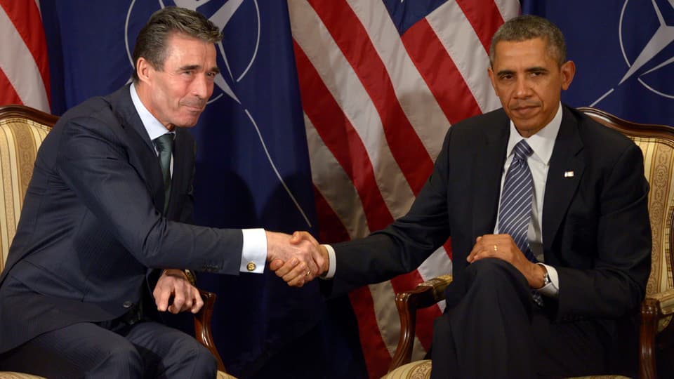Nato-Chef Rasmussen und Obama geben sich vor Nato- und US-Flagge die Hand.