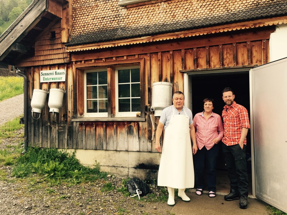 Nik Hartmann steht mit einem Ehepaar vor ener Käserei; dort werden Toggenburger Spezialitäten hergestellt. 